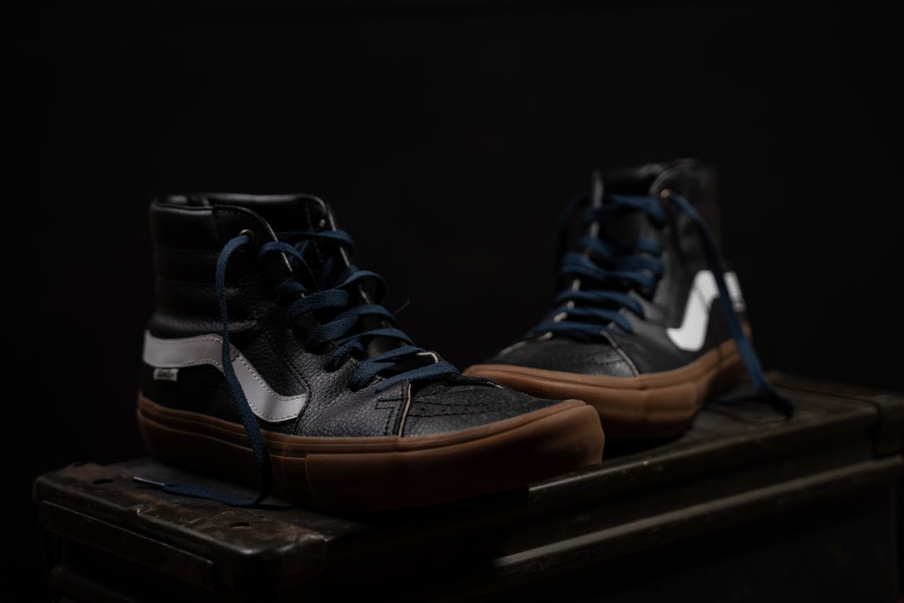 Stylish high-top leather sneakers with gum soles displayed on a dark background for product presentation.